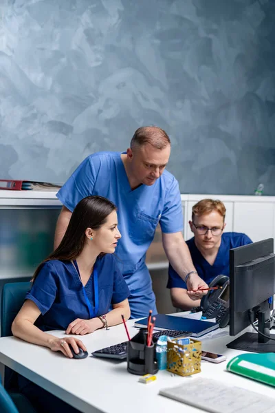 Három Orvos Dolgozik Orvosi Szaktudáson Miközben Asztalnál Ülnek Számítógép Előtt — Stock Fotó