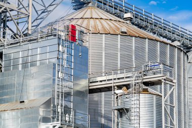 Tahıl deposu için güncel fabrika. Mavi gökyüzü arkaplanındaki metal silo tankları.
