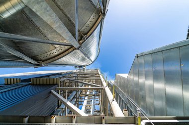 Hasat deposu için özel tahıl asansörleri. Metal tankın çatısından metal köprü. Aşağıdan bak. Yakın çekim..