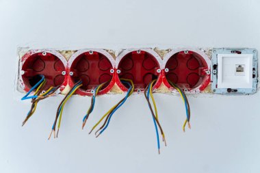 Elektrikli lenslerin kurulumu. Duvarda elektrik prizi sökülmüş. Tamir konsepti, elektrik bağlantısı. Yakın çekim..