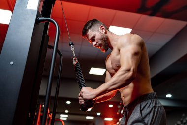 Spor salonundaki erkek eğitimine odaklan. Aşağıdan güçlü atletlerin ellerine bak..