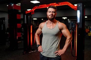 Gri gömlekli adam modern spor salonunda el ele tutuşuyor. Karanlık ışık. Yakın çekim..