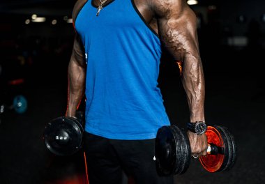 Afrikalı Amerikalı tanınmayan sporcu spor salonunda halterle egzersiz yapıyor. Çok güçlü eller..