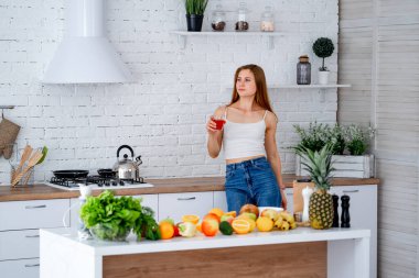 Diyet konsepti. Sağlıklı yiyeceklerle mutfağa yakın güzel bir genç kadın. Meyveler ve sebzeler.