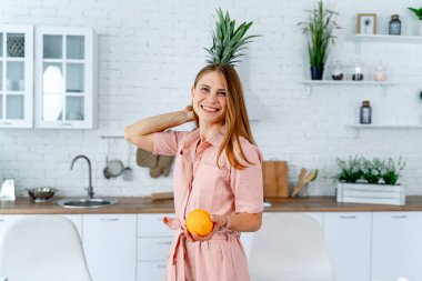 Diyet konsepti. Sağlıklı yiyeceklerle mutfağa yakın güzel bir genç kadın. Meyveler ve sebzeler.