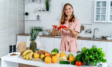 Ellerinde vişneli domates tutan bir kadın. Mutfak arka planı. Kesilmiş görüntü. Sağlıklı yemek..