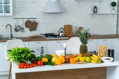 Sağlıklı yiyecekler, meyveler, sebzeler, böğürtlenler, mutfak arka planındaki masada salata yaprakları. Organik gıda konsepti. Modern mutfak