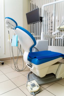 Modern sandalyeli dişçi ofisi. Diş temizleme ekipmanları güncellendi.