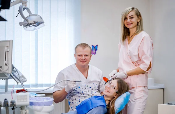 两名牙医检查病人的牙齿以进一步治疗 现代口腔科橱柜 — 图库照片