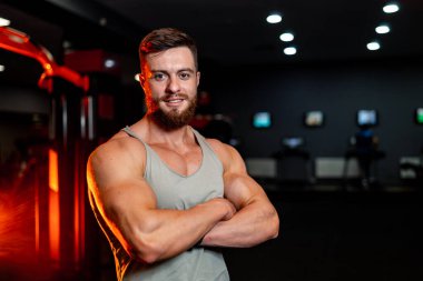 Güçlü kaslı sporcu çapraz duruş sergiliyor. Güçlü karın kasları olan mükemmel bir gövde. Jimnastik geçmişi olan yakışıklı bir erkek..