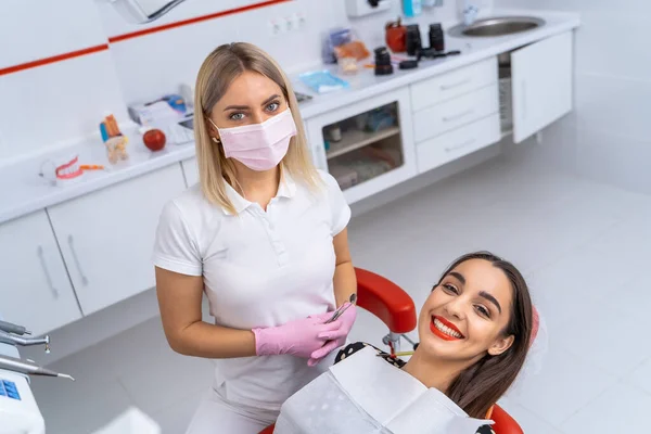 两个漂亮的女病人和牙医在牙科诊所的背景 戴着面具和擦拭 健康牙齿概念 — 图库照片