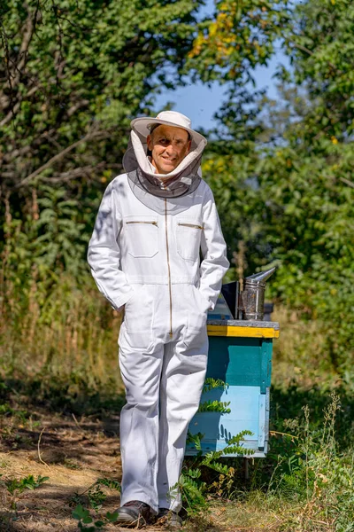 養蜂家は小さな養殖場の保護制服でカメラにポーズをとります 養蚕の概念 夏の一日 — ストック写真