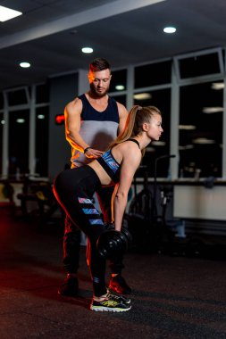 Kişisel yakışıklı fitness eğitmeni ve jimnastik salonundaki güzel sarışın bayan müşteri. Sağlıklı yaşam konsepti.