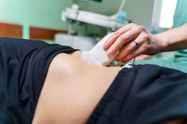 Doktorlar karın ultrasonu yapan bir hastaya el muamelesi yapıyor. Tıbbi araştırma.