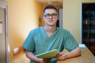 Profesyonel doktor kameraya bakar ve klasörü elinde tutar.. 