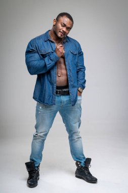 Kamera için poz veren kaslı yakışıklı vücut geliştirici. Mavi elbiseli atletik stil adamı.