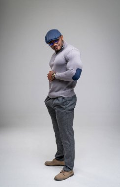 Kameraya poz veren yakışıklı seksi erkek. Stüdyoda şık kıyafetler içinde atletik model.