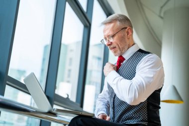 Gergin iş adamı dizüstü bilgisayarına bakıyor. Yetişkin bir adam çevrimiçi işleri için endişeleniyor..