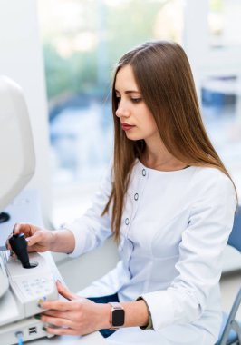 Konsültasyondaki mutlu kadın doktorun portresi. Güzel bir kadın hastaya teşhis koyarken ekrana bakar. Yakın çekim..