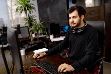 Bilgisayarda günlük kıyafetlerle çalışan yakışıklı bir adam. Bilgisayarda çalışan genç ofis yöneticisi.