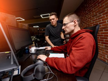 Modern ofiste çalışan, günlük kıyafetlerle meşgul, zeki bir erkek. Bilgisayar planlama ile çalışan yakışıklı iş adamı.