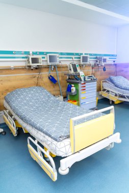 Hastane koğuşunda modern bir acil durum yatağı. Hastalar için konforlu ekipman.