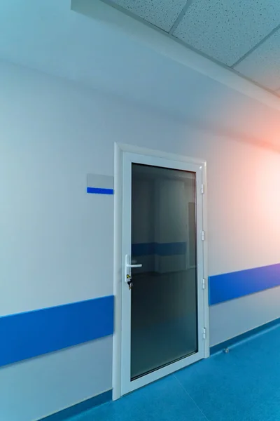 Modern comfortable door into hospital ward. Light white interior in hospital hall.