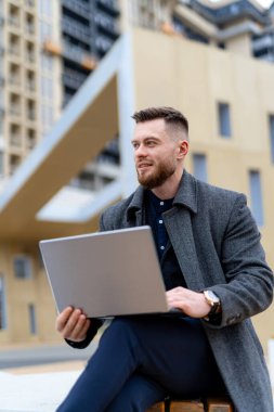 Sokakta dizüstü bilgisayarla çalışan şık ve yakışıklı bir iş adamı. Şehir sokağında günlük giysiler içinde genç çekici bir adam..