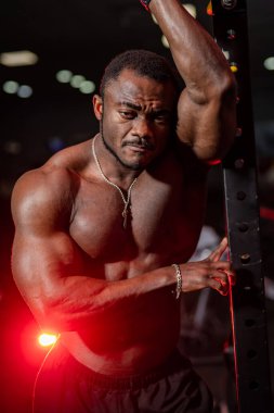 Kaslı adam kaslarını ve kaslarını gösteriyor. Güçlü çıplak erkek gövdesi. Pompalı vücudu olan Afrikalı Amerikalı bir adam.