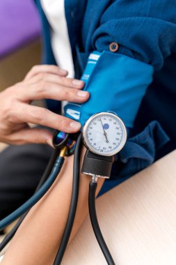 Basıncı ölçen doktoru kapatın. Tıbbi ekipmanlı hemşire tıbbi ölçüm yapıyor..