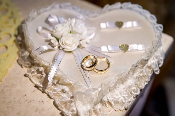 Wedding jewelry rings on the heart. Couple of shiny marriage rings.