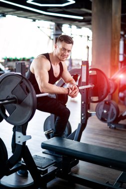 Spor salonunda çekici atletik erkek eğitimi. Genç adam spor yapıyor..