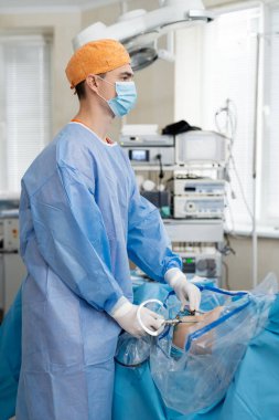 Tıbbi ekipman kullanılarak ameliyat işlemi. Cerrah ameliyathanede ameliyat ekipmanlarıyla. Tıbbi geçmiş.
