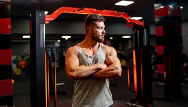 Spor salonunda poz veren yakışıklı kaslı adam. Sporcu güçlü vücut geliştirici.
