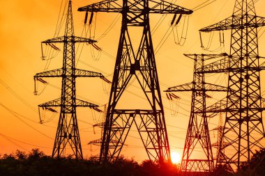 Yüksek voltaj kabloları ve şafak vakti. Şafak vakti gökyüzü arka planında elektrik direkleri. Gün batımında yüksek voltaj kuleleri. Aktarım hattı kulesi, günbatımı konsepti