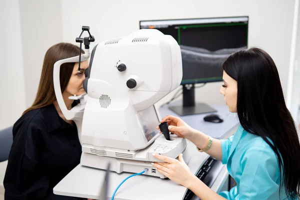 Morena Optometrista Fêmea Está Diagnosticando Mulher Equipamentos Modernos Especiais Clínica — Fotografia de Stock