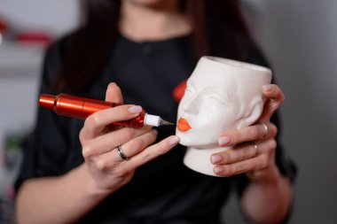 Çalışma modelinde kalıcı makyaj öğretmeni görünüyor. Stüdyosunda çok güzel bir kaş ustası var. Makyaj sanatçısı atölyesinde çalışıyor. Dudağına kalıcı makyaj yapan vize portresi.