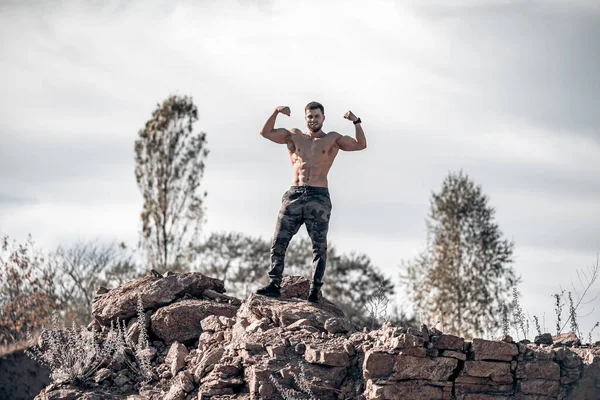 Fisiculturista Posando Livre Homem Rocha Com Músculos Tensos Vista Baixo — Fotografia de Stock