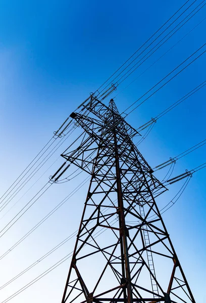 Dark silhouette of electric wire construction. Energy technologies tower shadows.