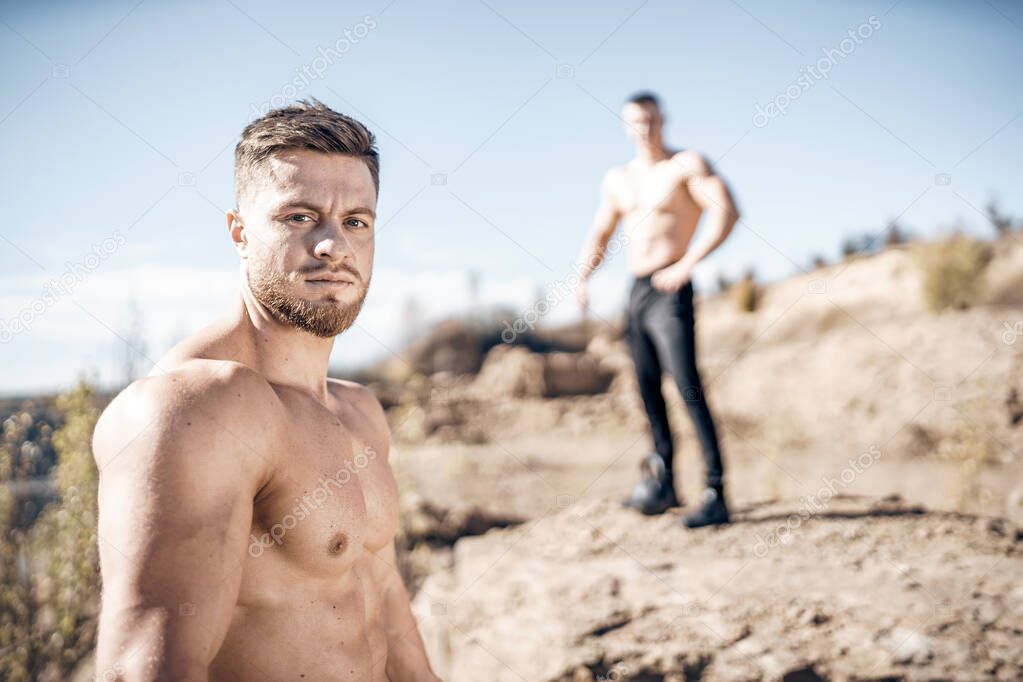 Two handsome shirtless man posing for camera. Attractive young male with naked torso.