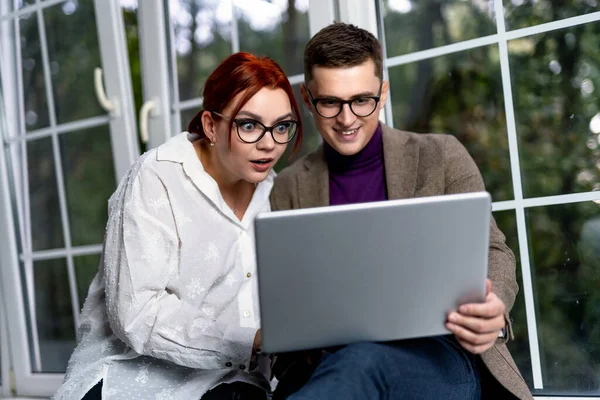 Dışarıda dizüstü bilgisayar kullanan serbest çalışanlar. Yakışıklı bir erkek ve güzel bir kadının portresi. Meslektaşlar proje üzerinde çalışıyor. Başarılı bir iş. Video konferansı