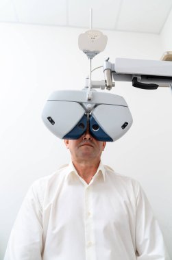 Görme kliniğinde göz muayenesi için donanım altında olan bir adamın ön görüntüsü. Klinikte modern teşhis. Kapat.