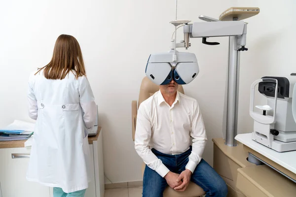 Женщина Оптометрист Проверяет Зрение Пациентки Мужчины Больнице Современное Оборудование Офтальмологической — стоковое фото