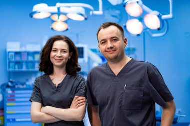 Ameliyathanede iki cerrah var. Koruyucu giysili iki cerrah ameliyathanede ameliyata hazır bekliyor..