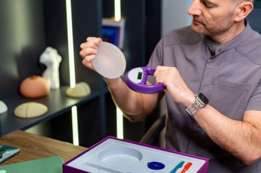 Plastik cerrah göğüs implantı için danışmanlık yapıyor. Doktor hastaya danışmanlık yapıyor. Göğüs implantı takıyor ve ameliyatın detaylarını anlatıyor..