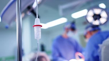 Cerrahi odasındaki kürsüye bırak. Kapatın. İki cerrah arka planda çalışıyor..