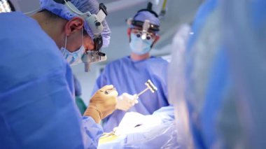 Nörocerrahlar operasyonda metal aletler kullanırlar. Cerrahın cerrahi hoparlör takıp enstrüman kullanmasına düşük açılı bakış açısı.