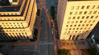 Saint-Louis, Missouri, ABD 'nin boş geniş şeritli sokakları. Güneşle aydınlatılmış devasa binaların yakınındaki drone görüntüleri..