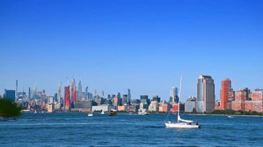 New Jersey, ABD, 19 Ağustos 2025: Sürat tekneleri ve yelkenliler güneşli bir günde Doğu Nehri 'nden geçiyor. Arka planda New York silueti.