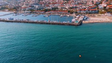 Mavi deniz manzarası üzerinde tekneler için rıhtım boyunca uçuyor. Bulgaristan 'ın Sveti Vlas kentindeki güneşli tatil beldesine bak.